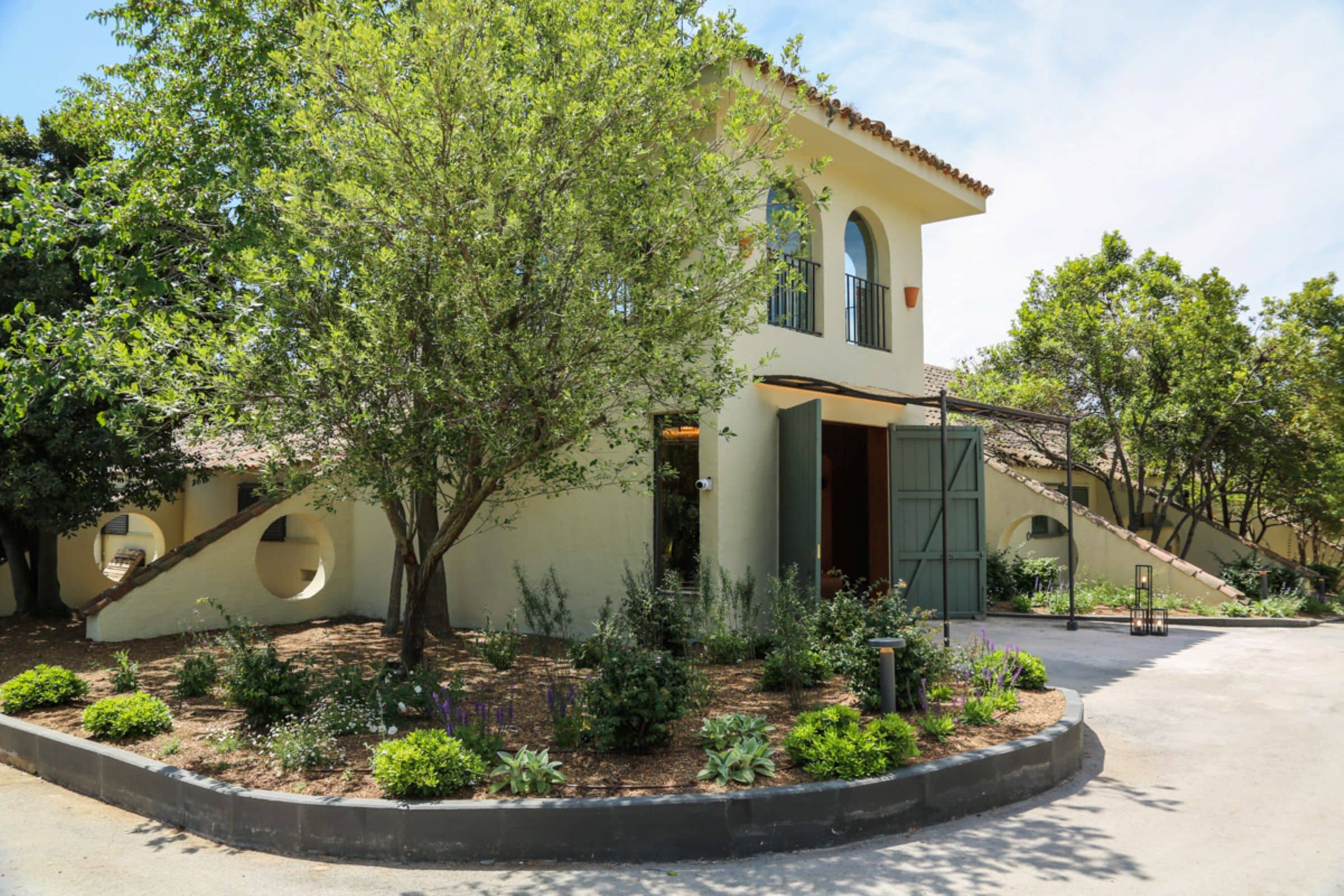 Fachada exterior del Cortijo de Mónico, rodeada de exuberante vegetación, uno de los mejores lugares para bodas en Madrid.
