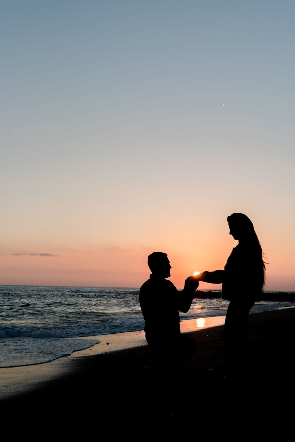 Pedida de mano al atardecer en la playa.