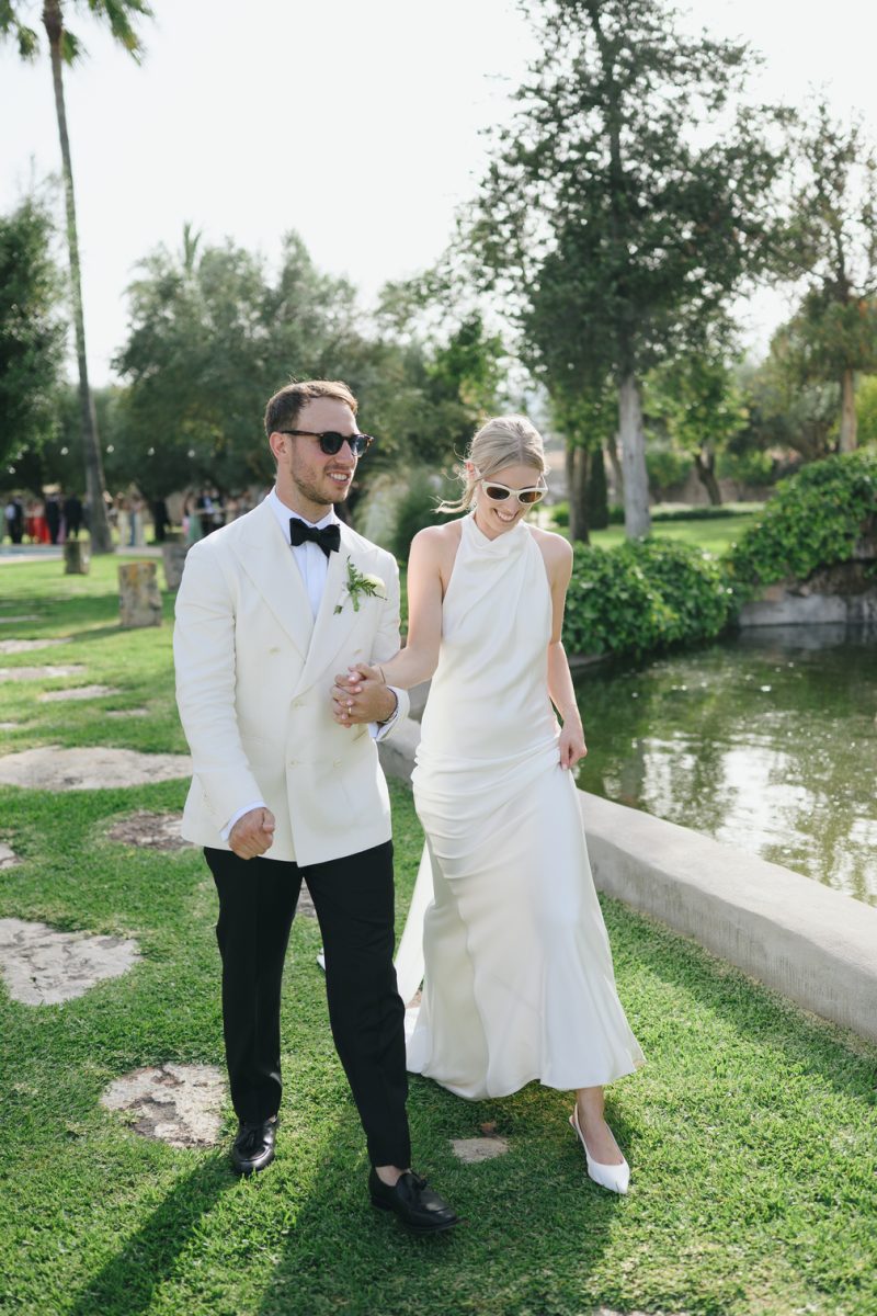 Sophie and Rory walking by the pond at Finca Morneta, both dressed in white