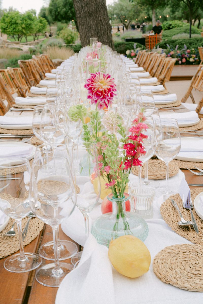 A long table with pink dahlias and lemons at Finca Morneta, at Wendy and Jason's wedding