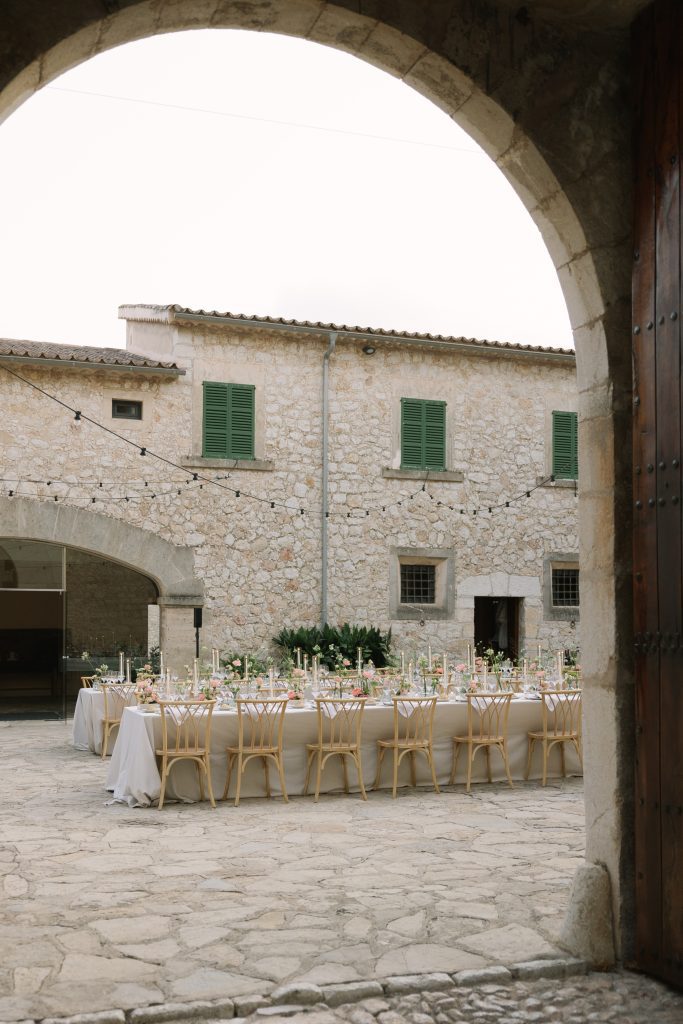 Dinner tables in the courtyard at Son Berga, seen through an archway