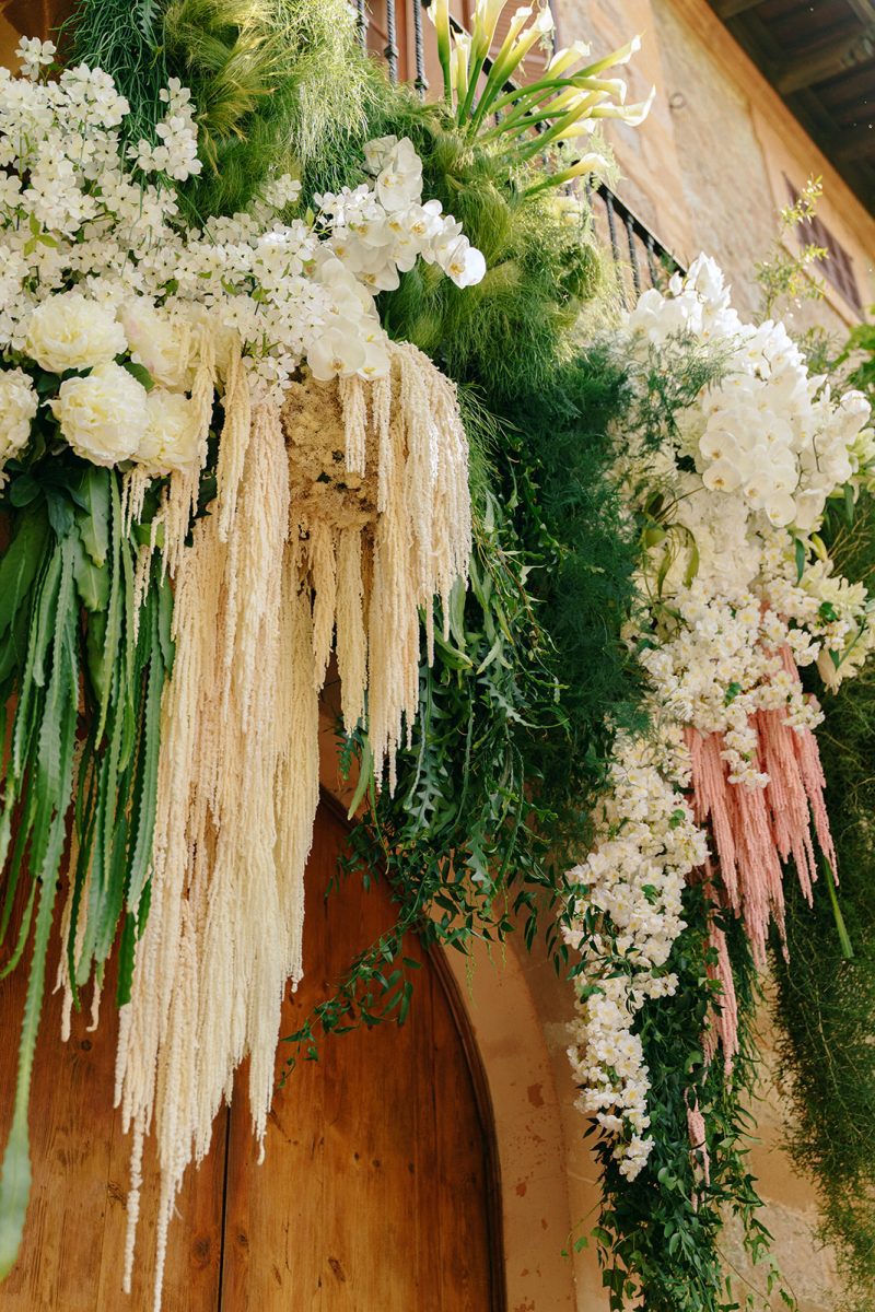 Arreglo colgante de flores blancas y pampas sobre la puerta de la ceremonia en Son Togores