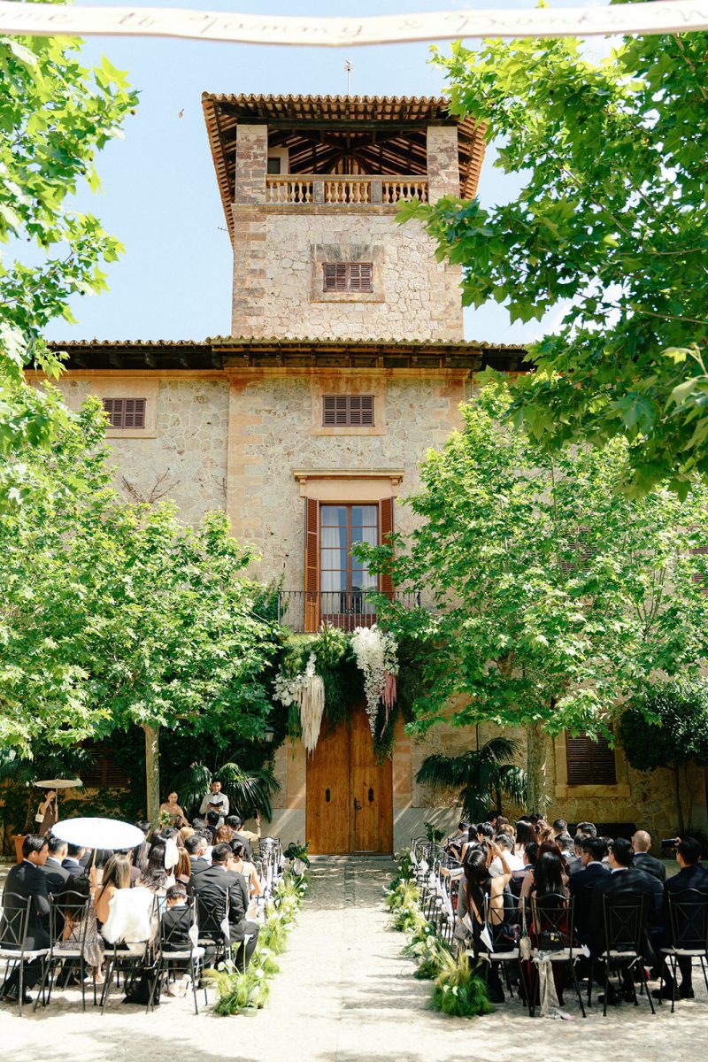 Invitados sentados en el patio de Son Togores durante la ceremonia, frente a la torre