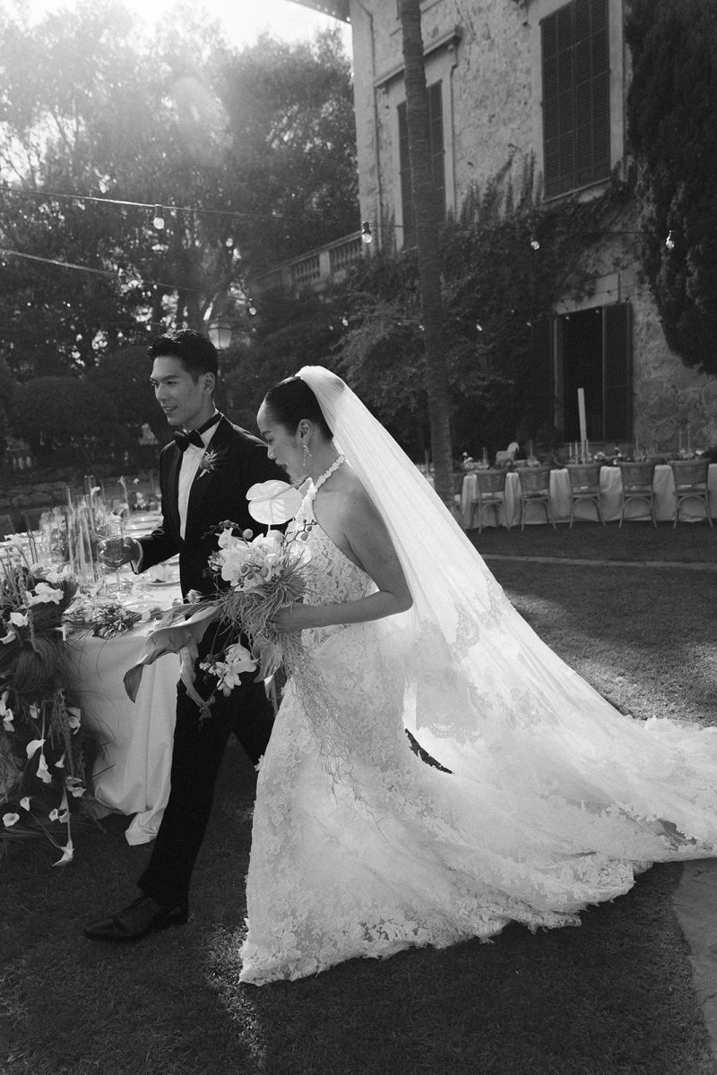 Tammy y Frank pasean por el patio durante el cóctel, en blanco y negro
